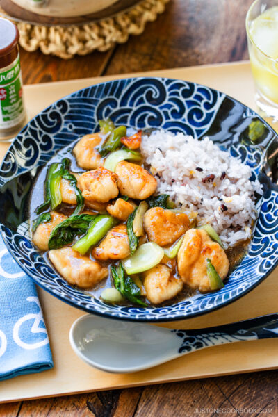 A large shallow bowl containing multi-grain rice and Chicken Bok Choy Stir Fry.